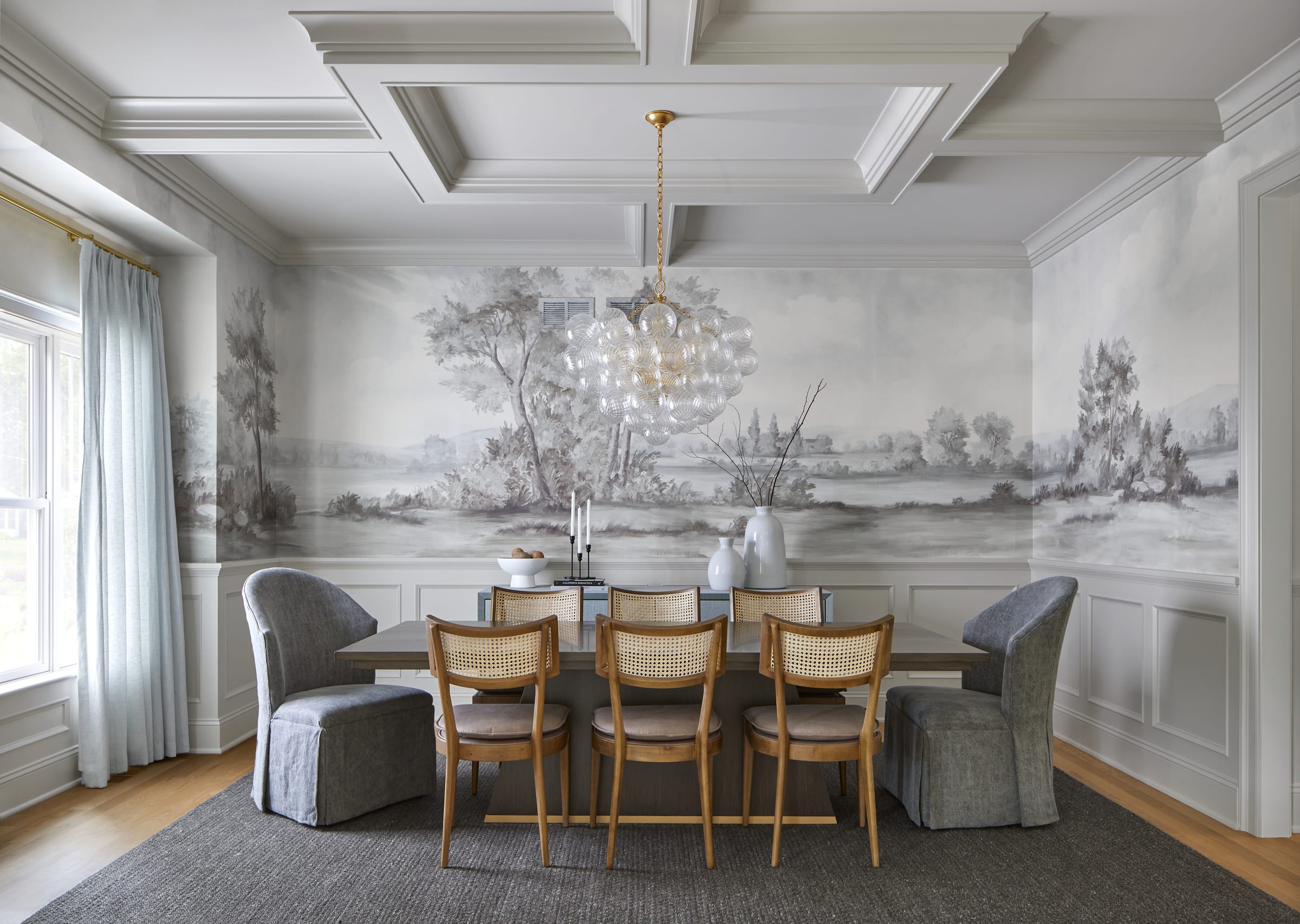 Dining room with hand-painted mural wallpaper and cane-back chairs in a Chatham, NJ home by Ellie Mroz Design.