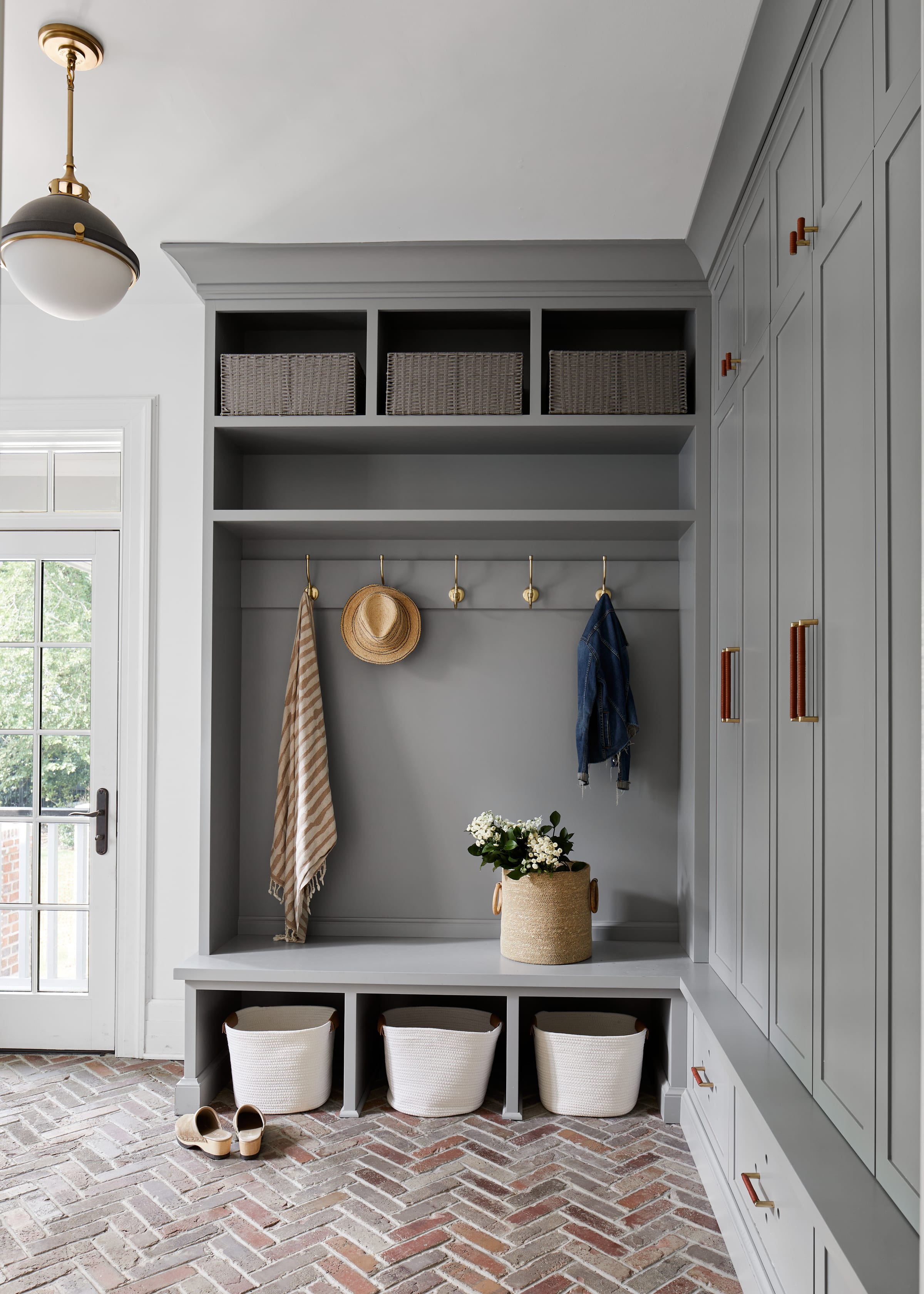 Mudroom with custom built-in storage and herringbone brick floors in historic Westfield NJ home.