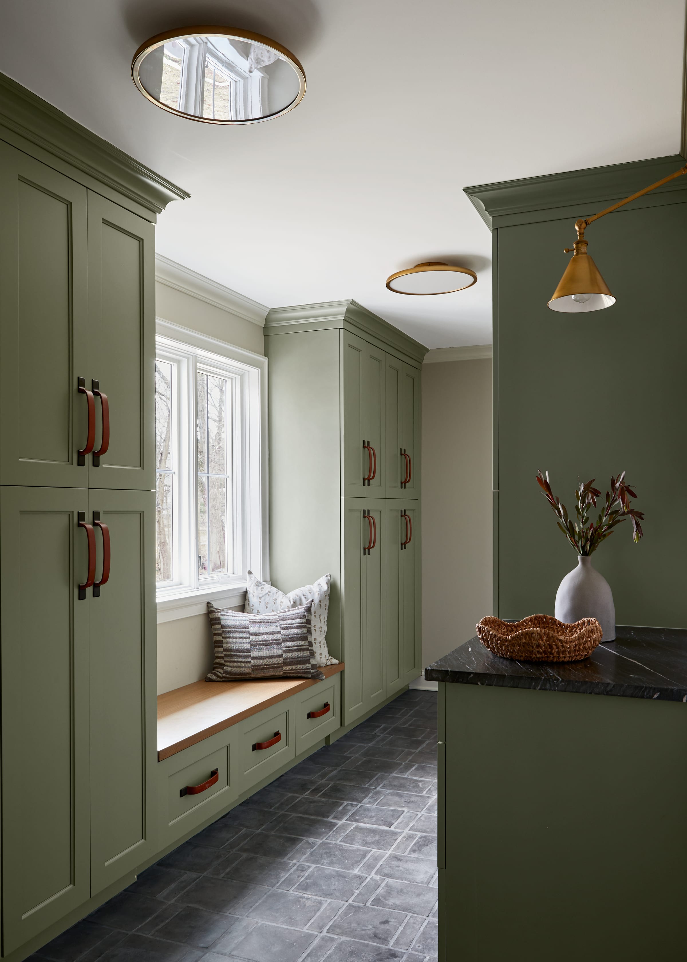 Green mudroom cabinetry with oak bench in a Westfield, NJ home addition and renovation.