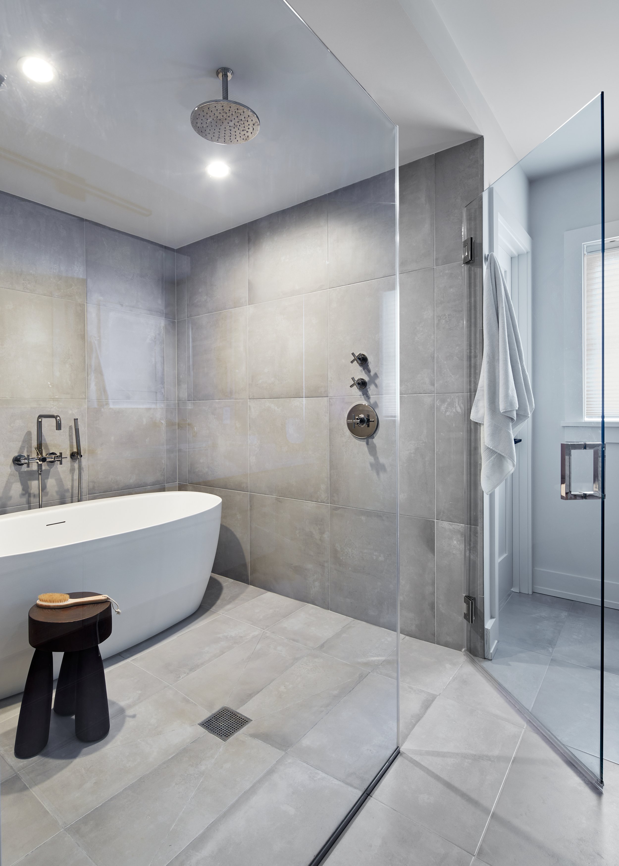 Primary bathroom wet room with a freestanding tub set inside the open glass shower area in a Westfield, New Jersey home by Ellie Mroz Design.